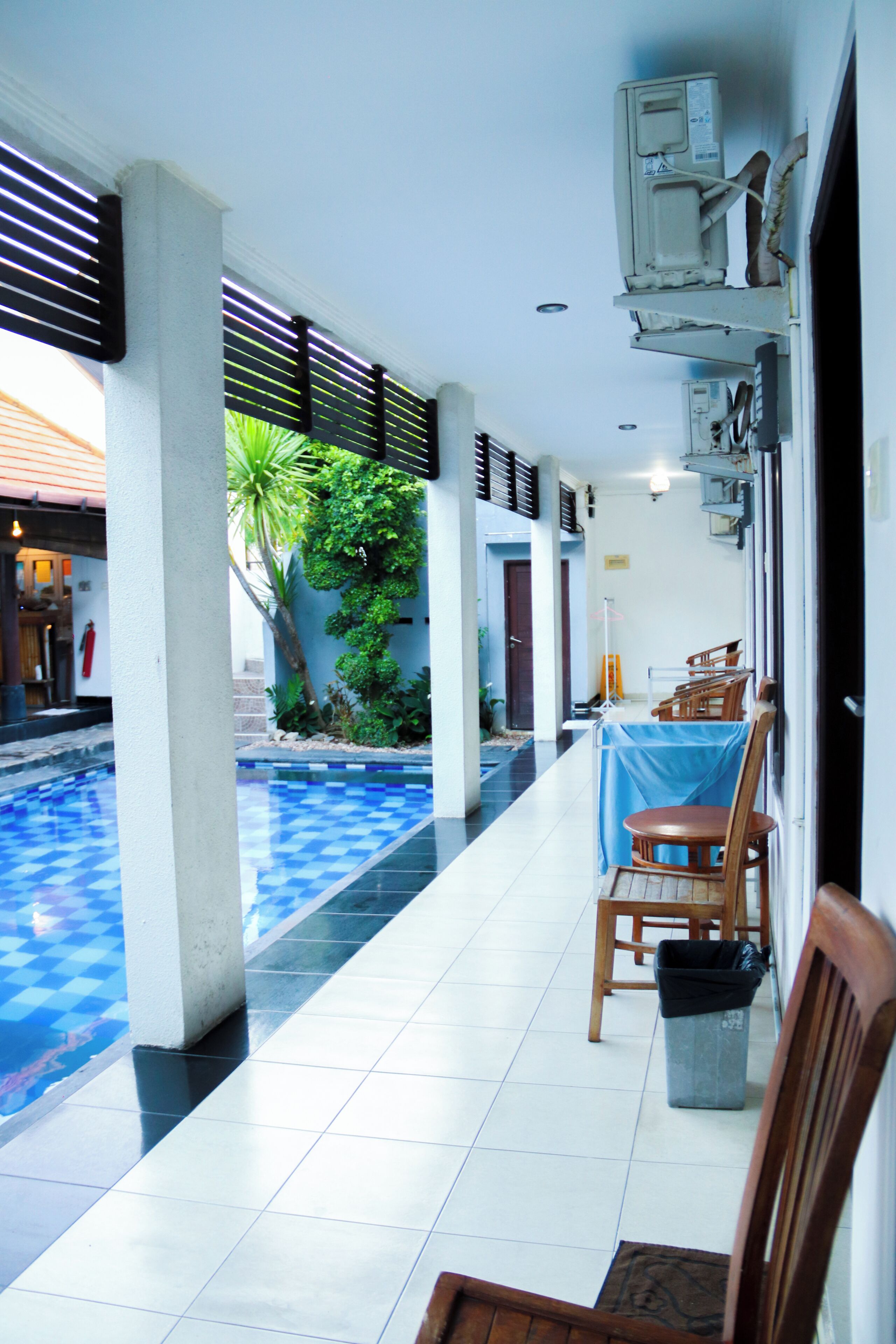 A covered outdoor area with a pool, chairs, and tables, suggesting a lounge or dining space.