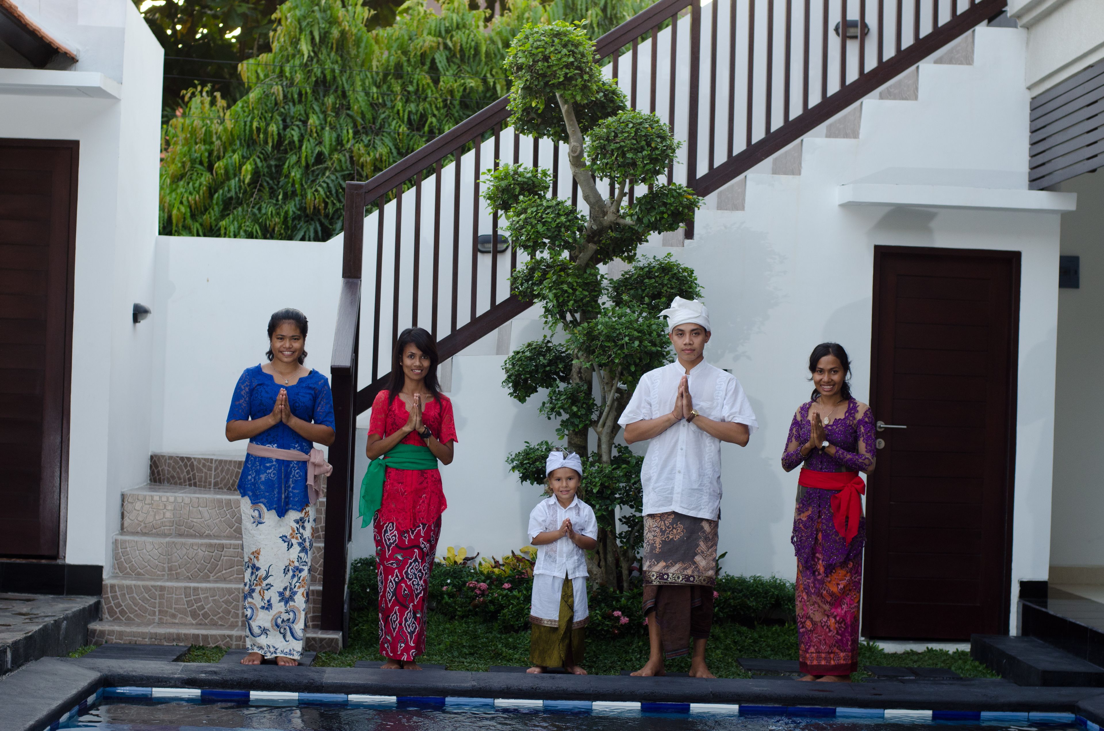 A group of people standing in front of a staircase with a pool at the bottom.