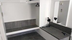 A bathroom with a white vanity, dark grey tiles, a black lamp, and a mirror. - Aspley Sunset Motel (Aspley)