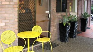 A brick building with a glass door labeled "Office." Inside, there are yellow chairs and a small round table. - Motel Northview Mackay (Mount Pleasant)