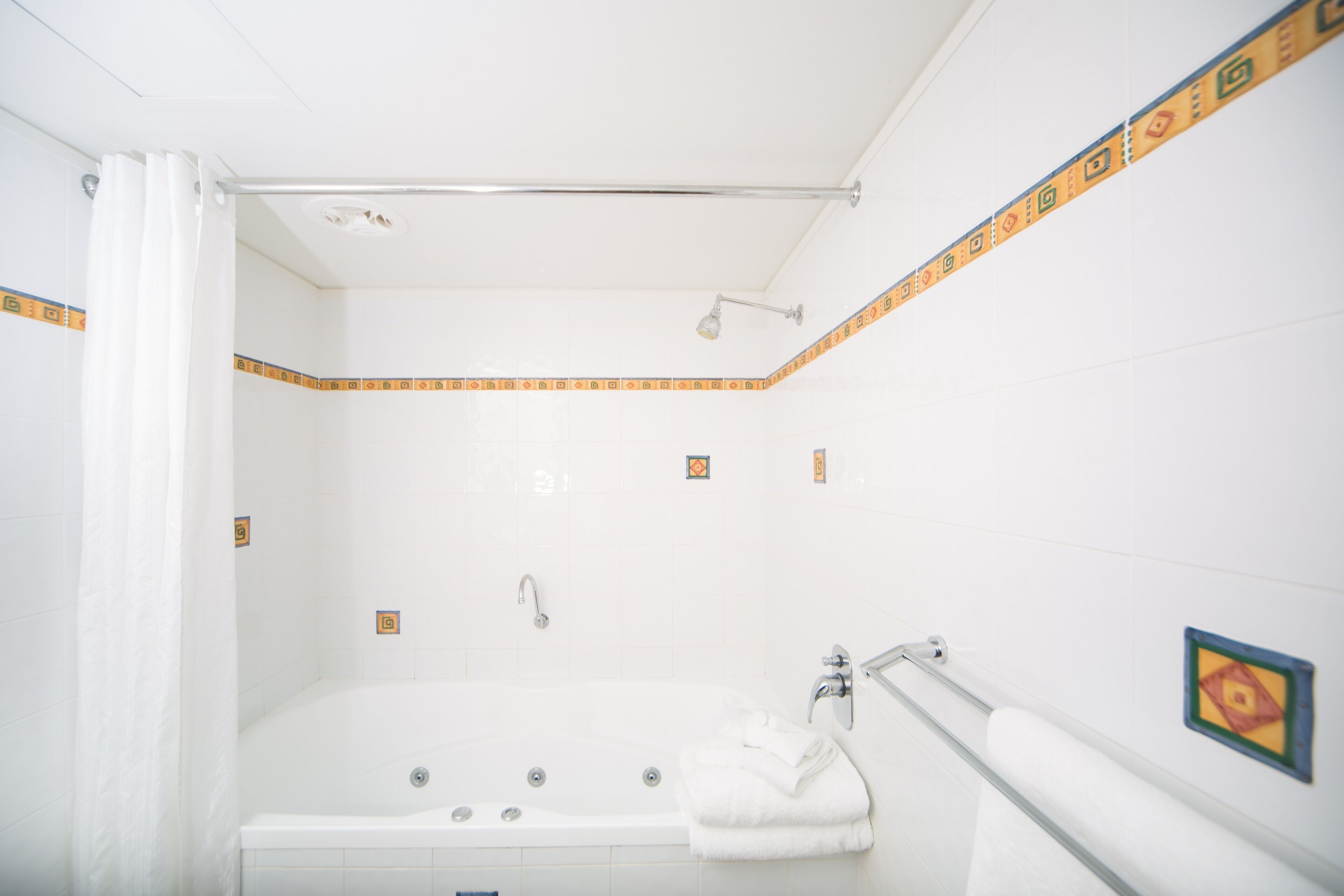 Ein Badezimmer mit Badewanne, Dusche und Handtuchhalter.