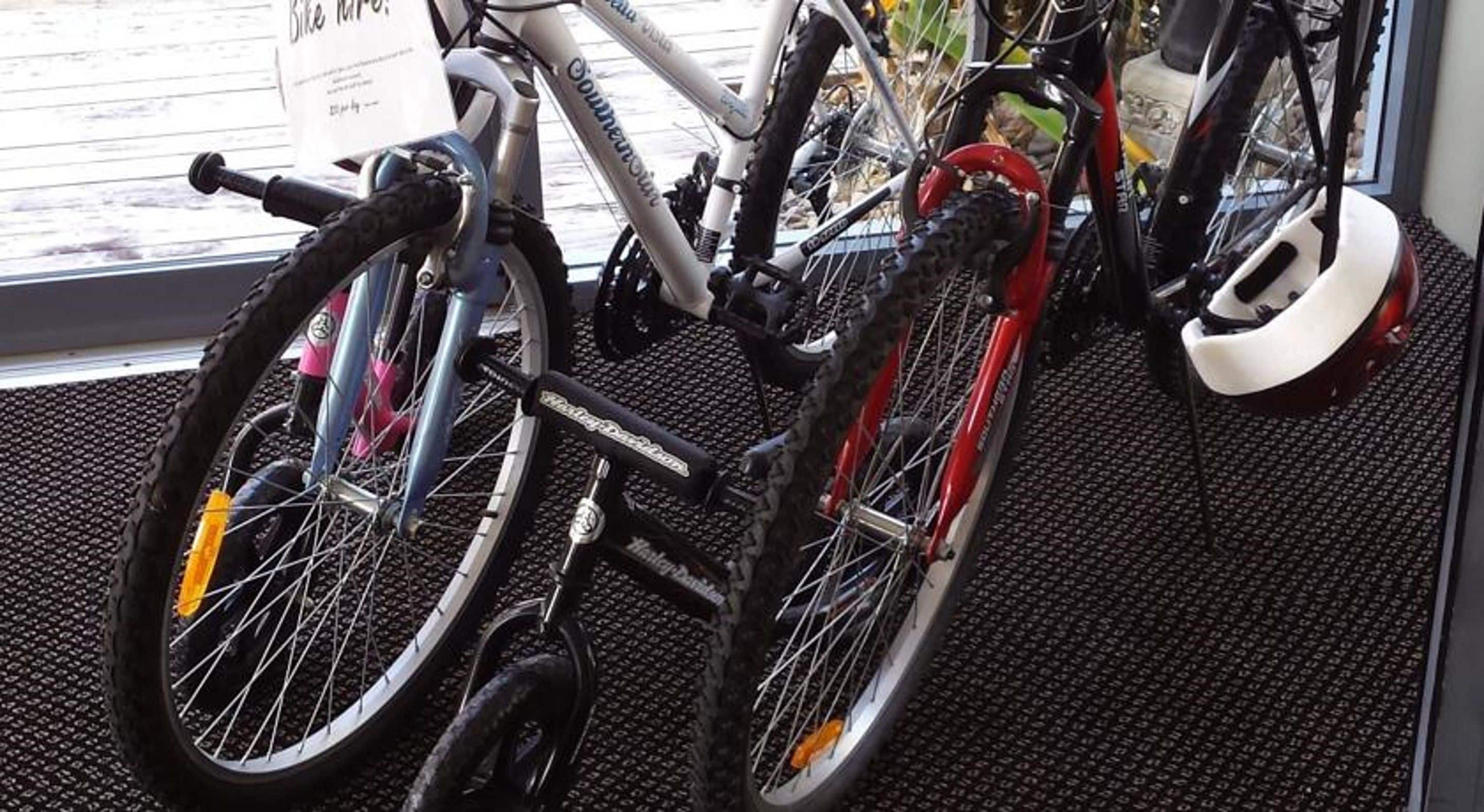 A bicycle with a black frame and a white seat, parked indoors.