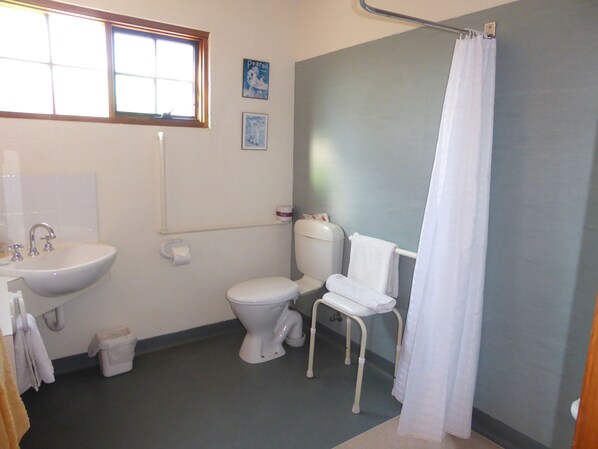 A bathroom with a sink, toilet, and shower curtain.