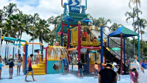 Een waterpark met een grote waterglijbaan en speelconstructies.