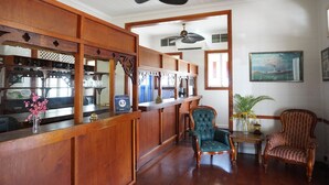 Een klassiek interieur met houten lambrisering, een bar en zitplaatsen.