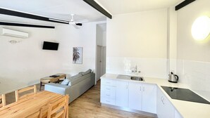 Een moderne keuken met witte kasten, een zwart aanrecht en een ingebouwde kookplaat.