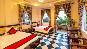A hotel room with two beds, checkered floor, curtains, a table with chairs, and a view of greenery outside. - Moon's Homestay (Da Nang)