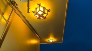 A balcony with wooden benches and a wall-mounted light fixture. - Moon's Homestay (Da Nang)