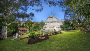 A large two-story house with a balcony, surrounded by a well-maintained lawn and trees. - 65 Main Daylesford - Hepburn Springs (Hepburn Springs)