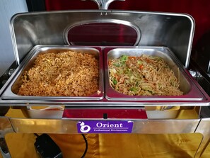 A buffet with two metal trays, one containing fried rice and the other noodles with vegetables. - Agga Youth Hotel (Yangon)