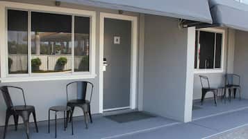 A building with a covered outdoor seating area, a door marked with the number 4, and two windows.