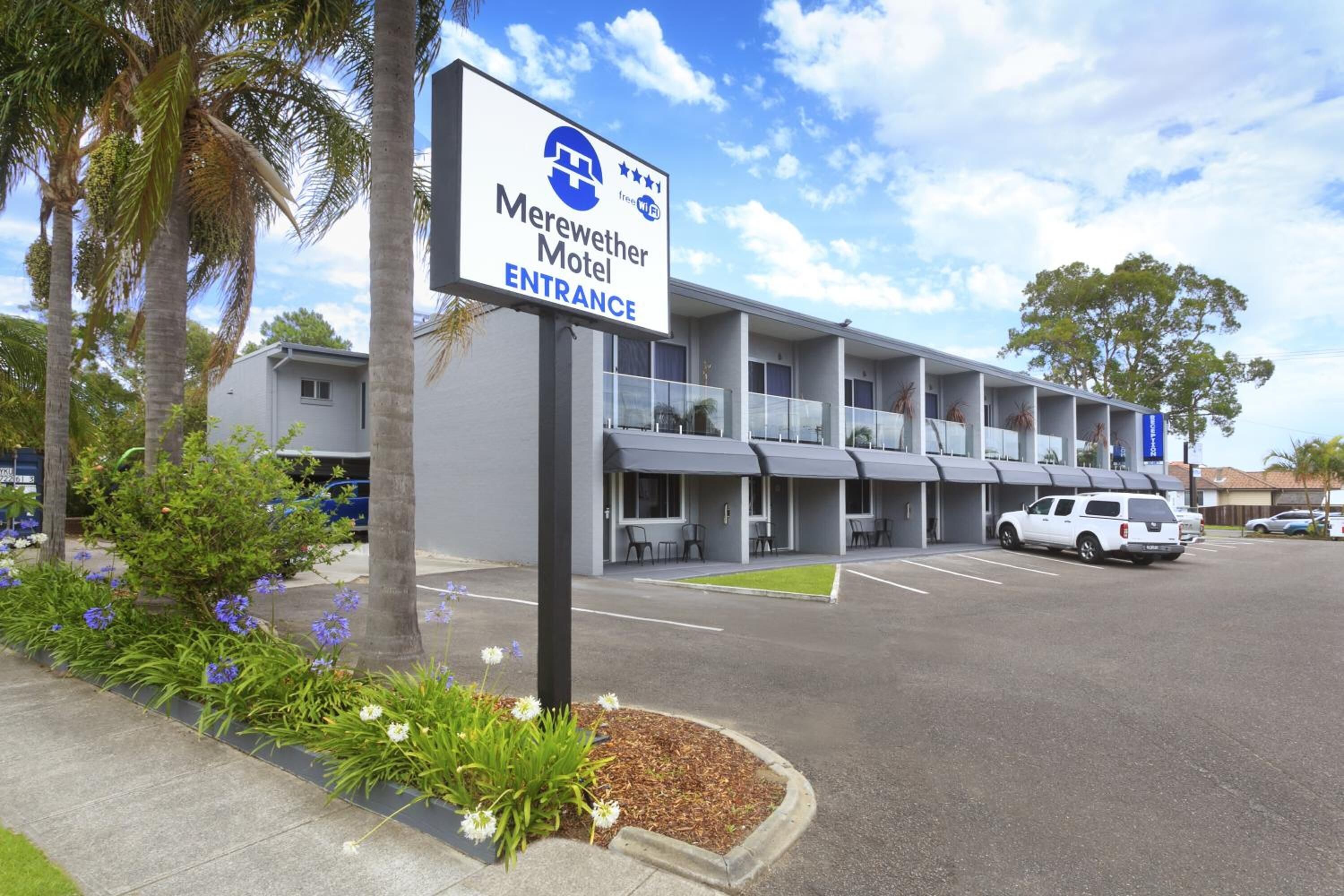 A motel with a sign indicating the entrance.