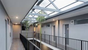 Ein modernes Interieur mit Glasdecke, einem zentralen Atrium und einer Treppe.