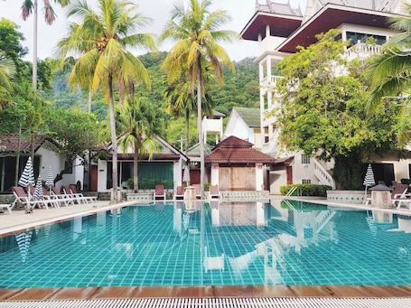 Una piscina al aire libre, sillones reclinables de piscina