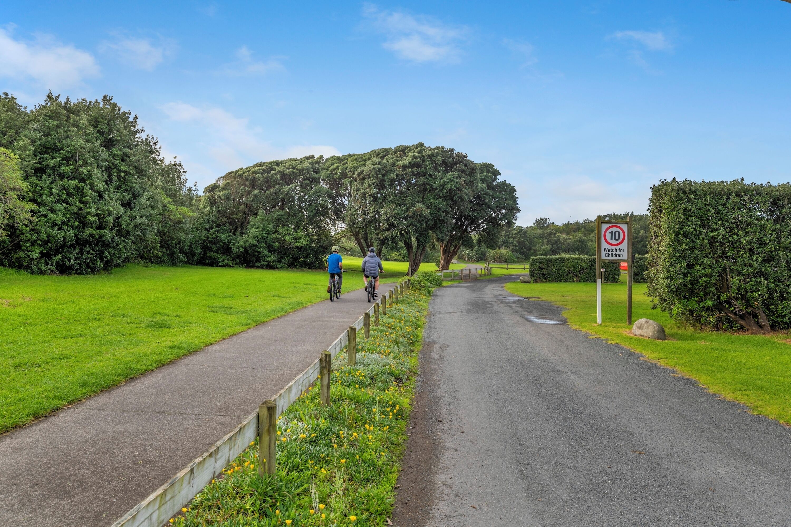 Un chemin pavé avec un panneau indiquant la limite de vitesse et un panneau d’avertissement indiquant la présence d’enfants.