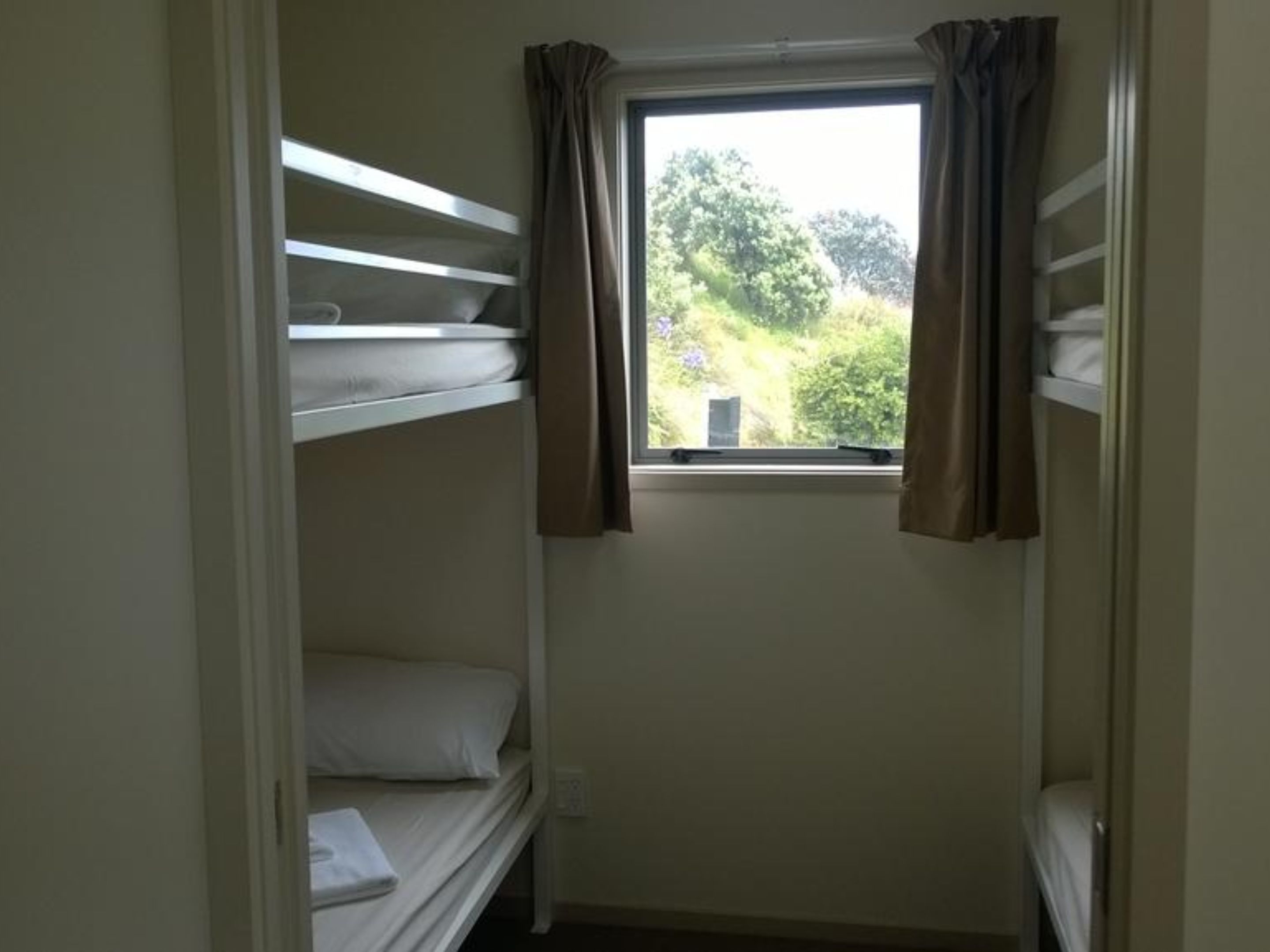 Habitación con literas, ventana y cortinas.