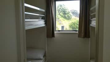 Habitación con literas, ventana y cortinas.