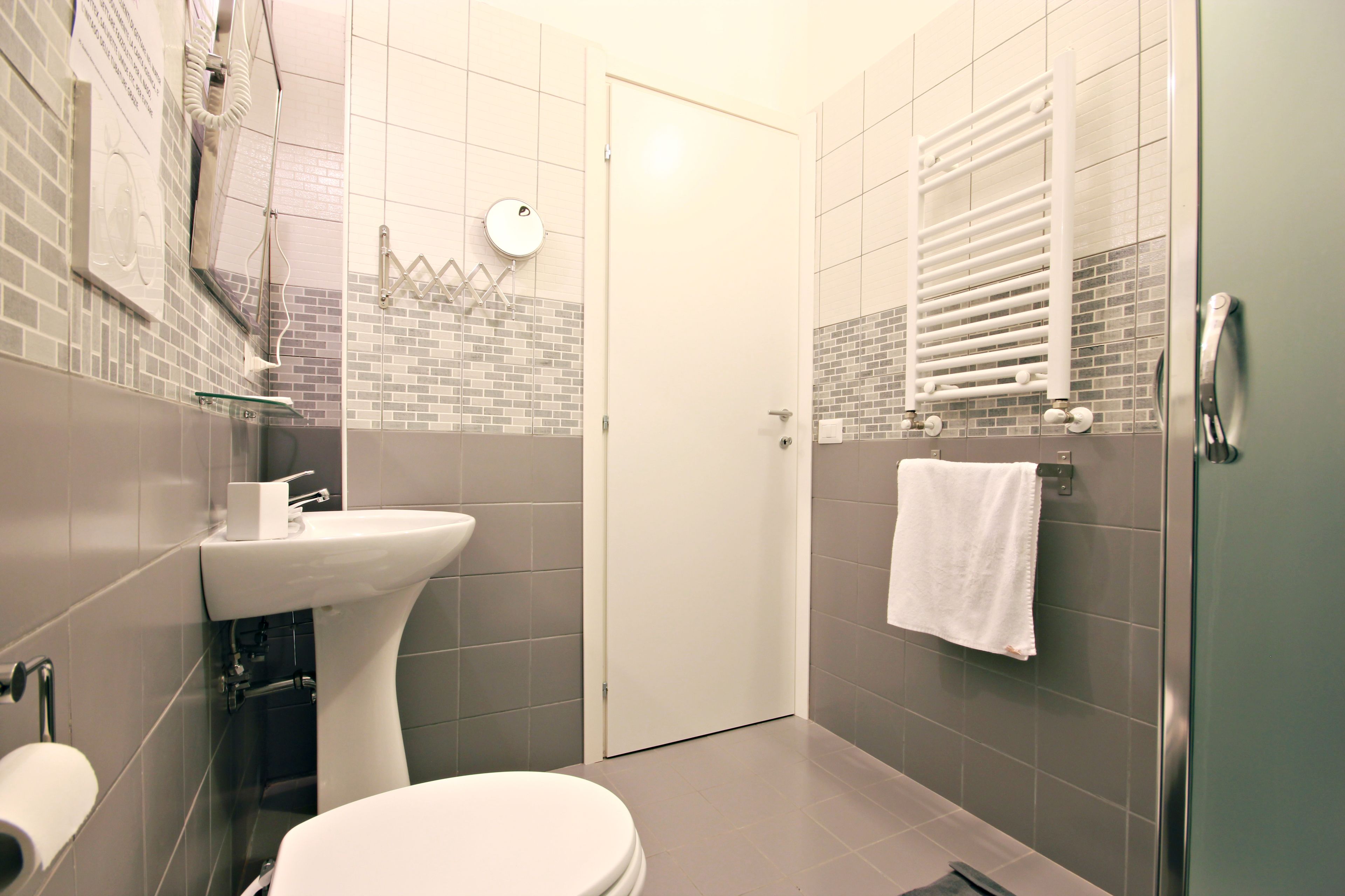 A modern bathroom with a toilet, sink, and shower area.