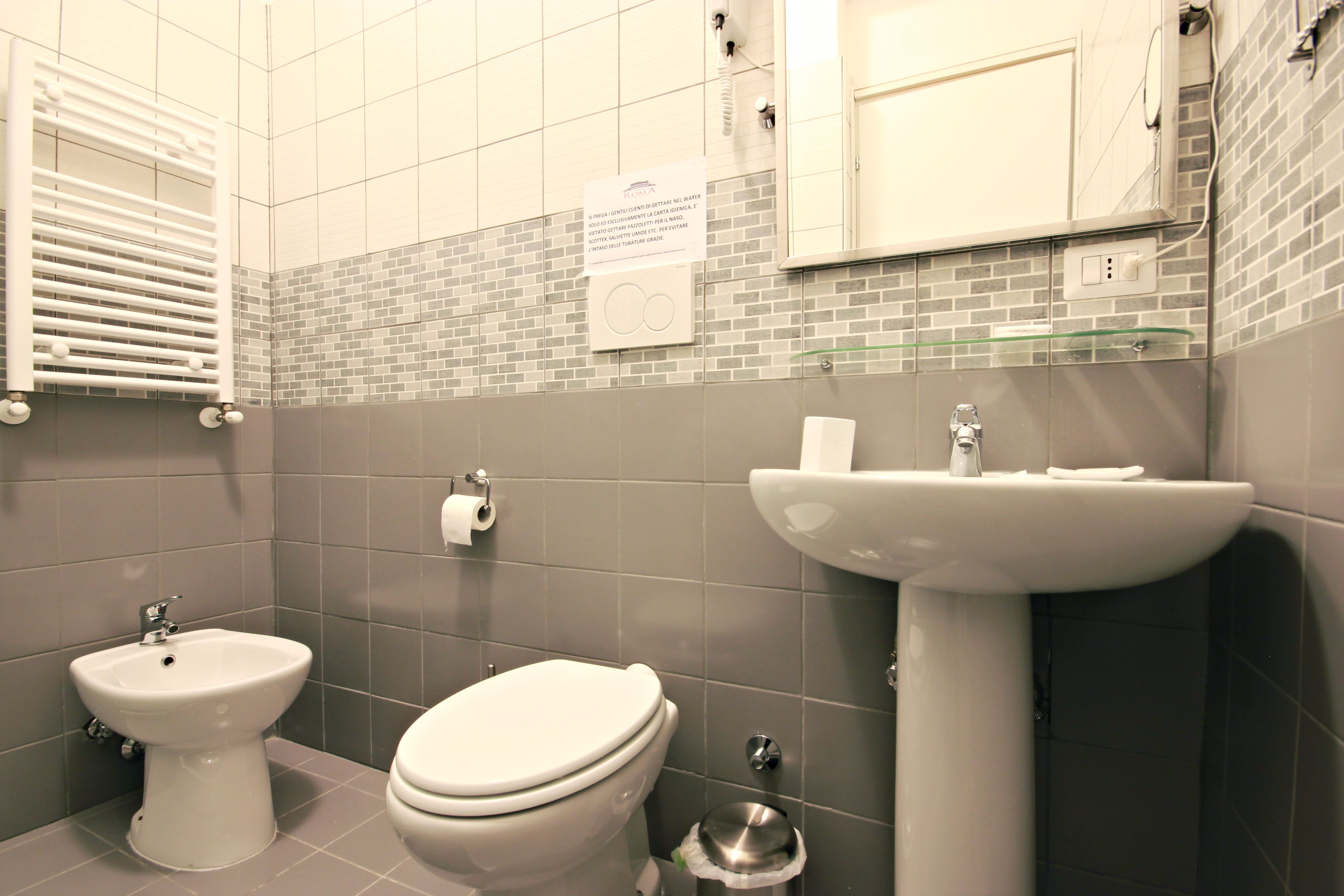 A bathroom with a toilet, bidet, and sink.