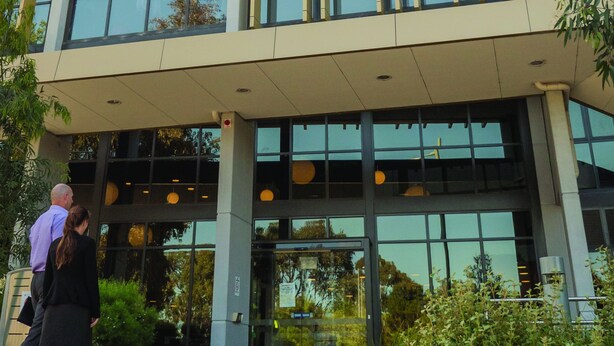 A modern building with a glass facade and vertical wooden slats. - Deakin Residential Services (Burwood)
