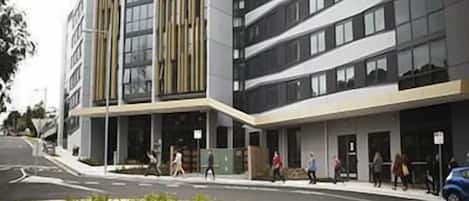 Een modern gebouw met een plat dak, grote ramen en een centrale ingang.