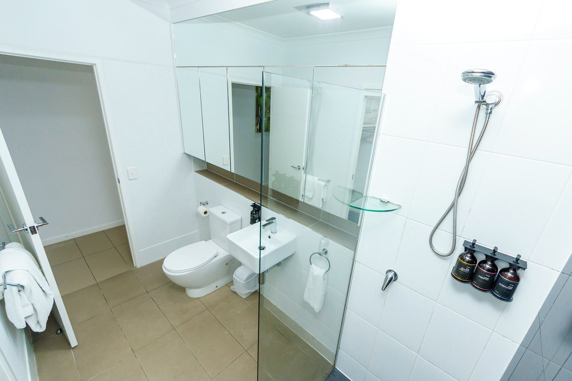 Un baño moderno con inodoro, lavamanos y ducha.