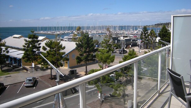 A marina with numerous boats docked, a clear sky, and a view of the sea. - The Waterfront Apartments, Geelong (Geelong)