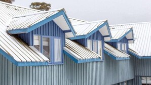 A row of blue-roofed buildings with dormer windows. - Alpenhorn (Thredbo)