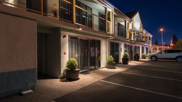 A modern hotel with a two-story structure, large windows, and a parking area. - Gladstone Motel Nelson (Richmond)