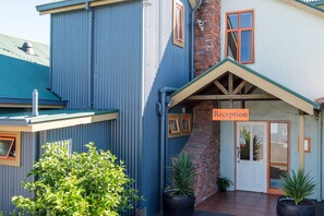 Welcome to our charming two-story building with a reception area, featuring a unique blend of corrugated metal and brickwork.