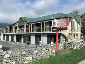 Welcome to the Gladstone Motel, a two-story building with a green roof and a prominent sign.