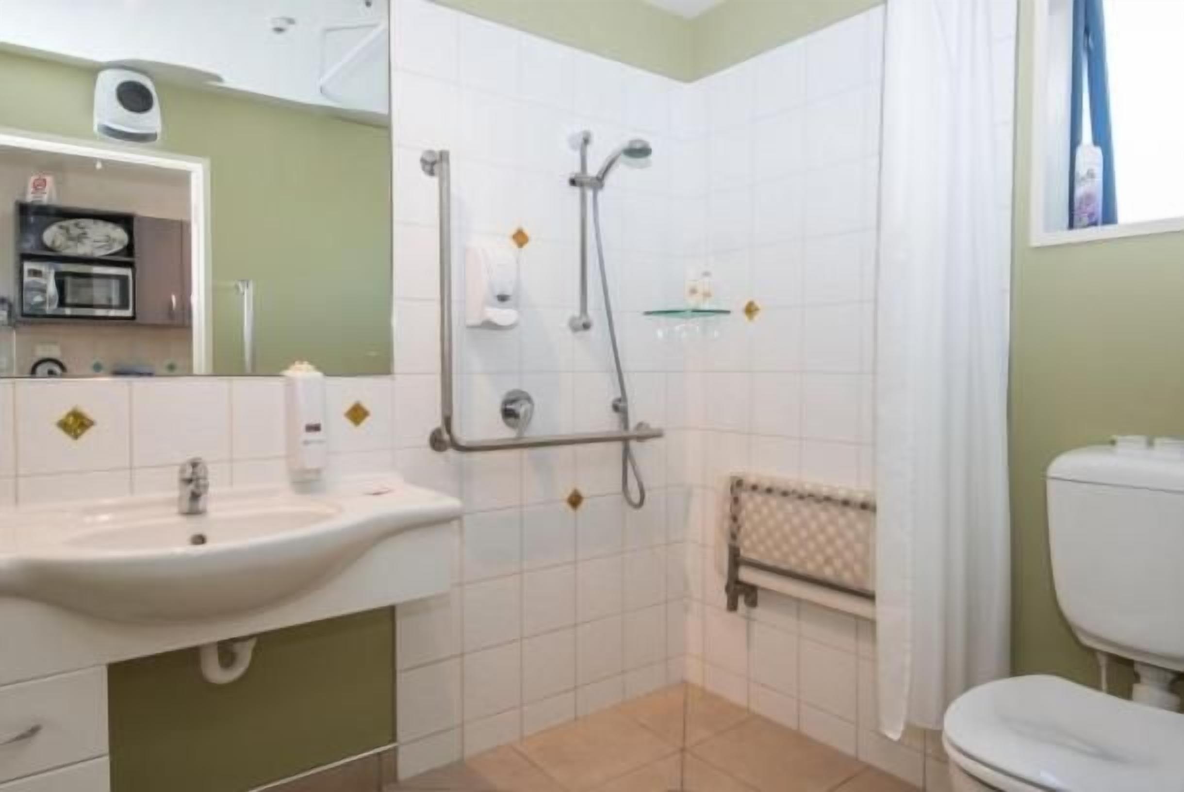 A bathroom with a sink, shower, and toilet.