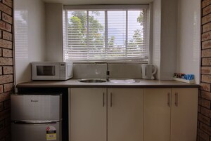Cocina compacta con microondas, hervidor y refrigerador.