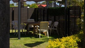 A covered outdoor seating area with a sign for Tuncurry Motor Lodge.