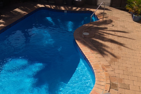 Una piscina al aire libre, tumbonas