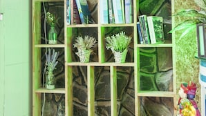 A wooden bookshelf with books and small potted plants. - Koniko hotel (Ho Chi Minh City)
