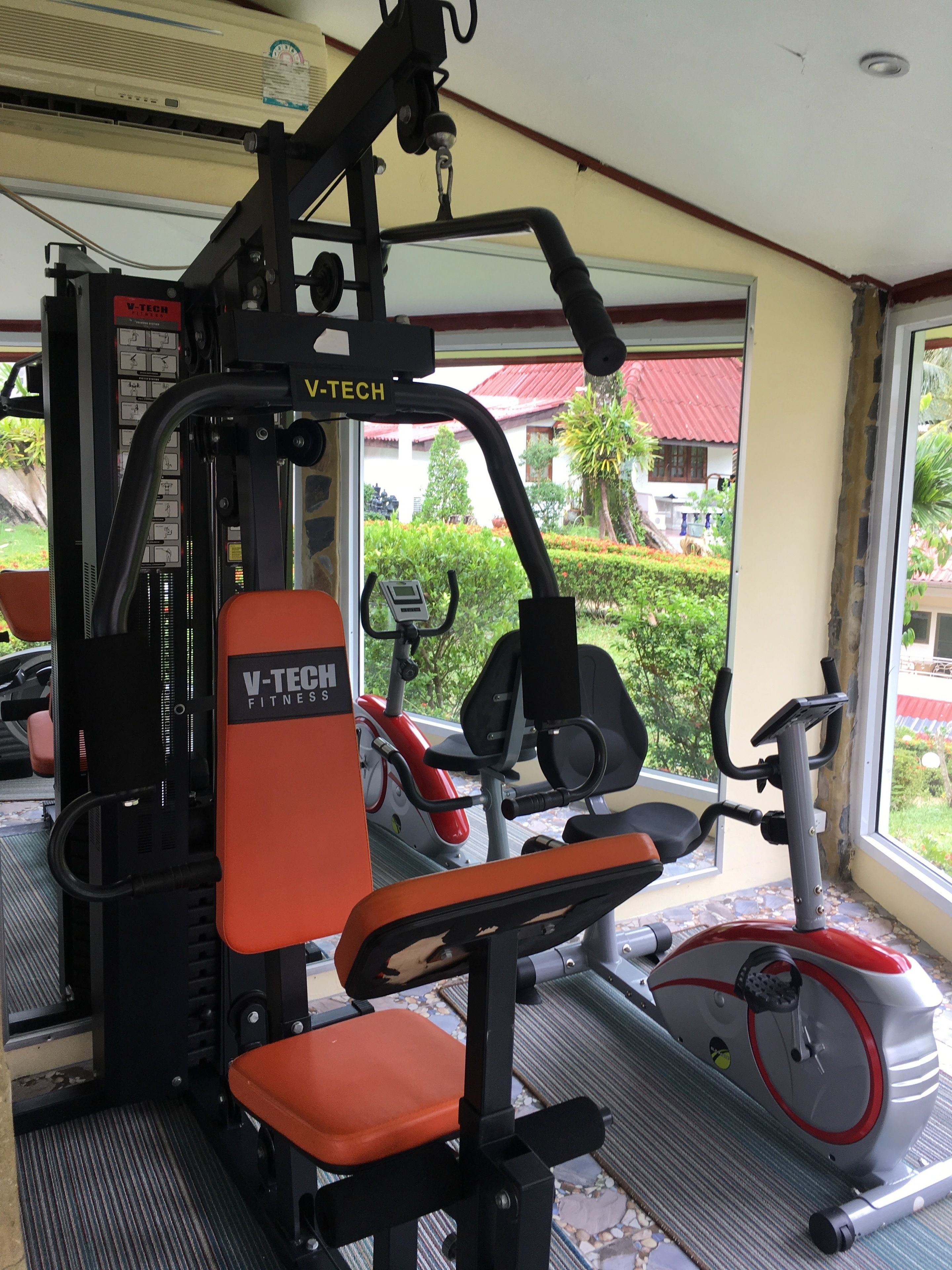 A gym with V-TECH fitness equipment, including a bench press and an elliptical machine.