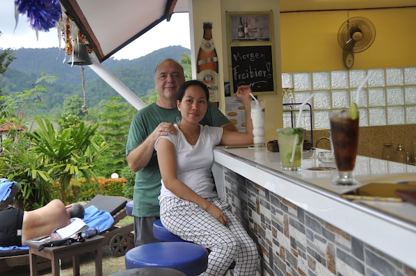 Zona de bar con vistas a montañas, un ventilador y un panel de menú.