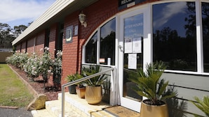 A reception area with a sign indicating after-hours contact. - Seymour Motel (Seymour)