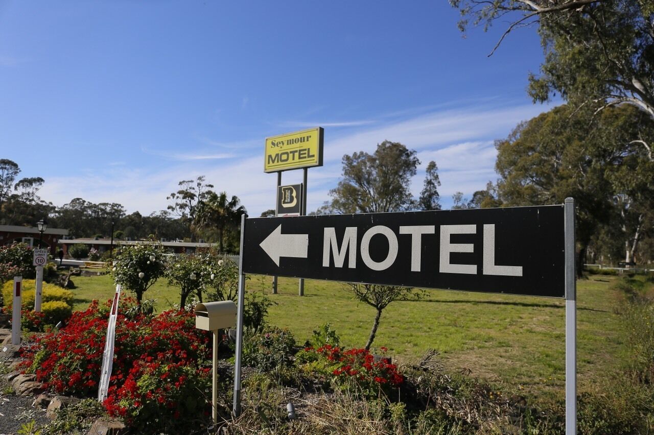 Une enseigne de motel avec une flèche indiquant la direction, pointant vers la gauche, pour indiquer la direction du motel.