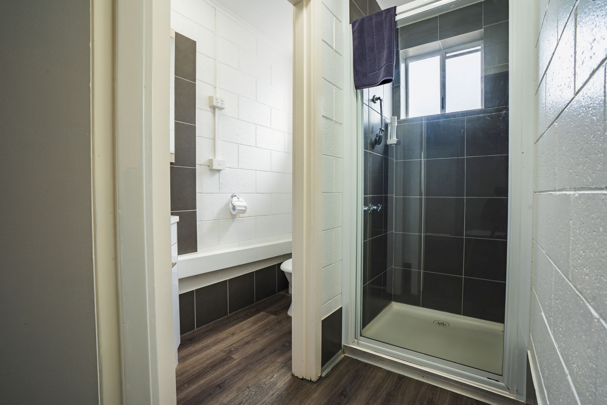 A bathroom with a shower, toilet, and a sink.