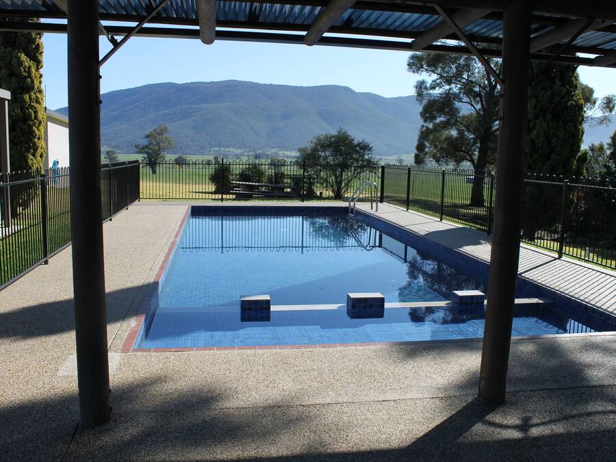 Una piscina al aire libre, sillones reclinables de piscina