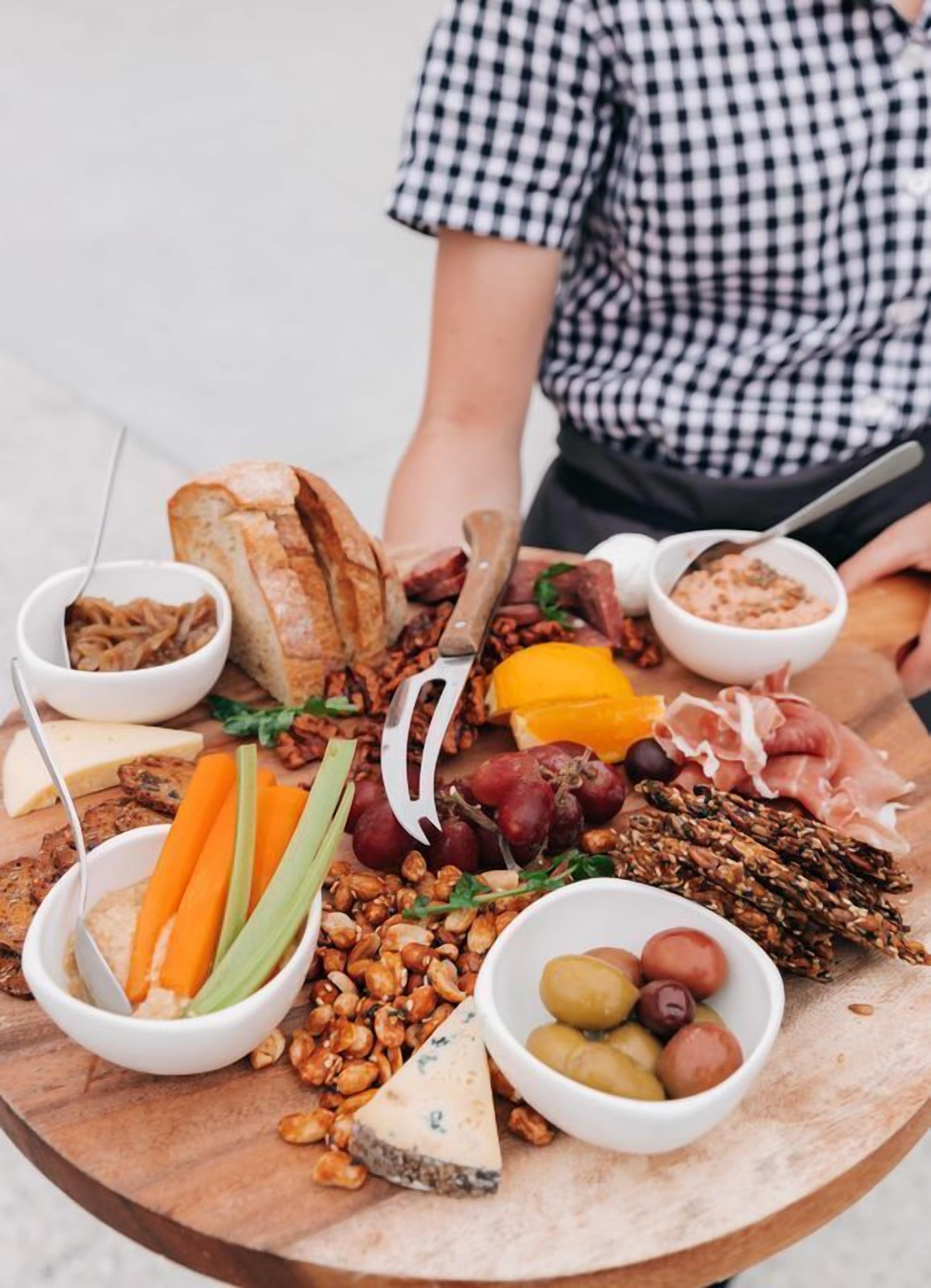 A charcuterie board with various meats, cheeses, and vegetables.