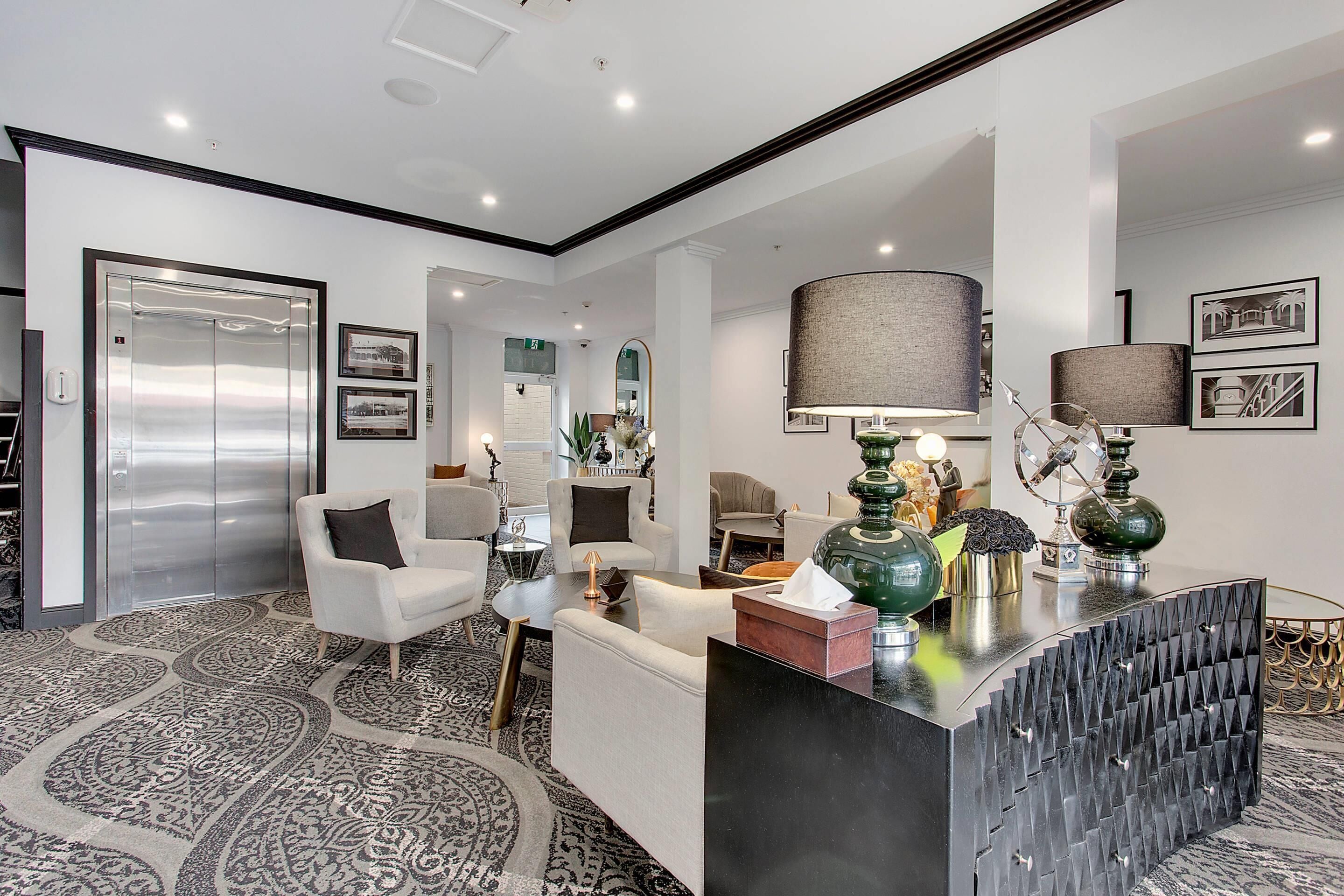 A modern living room with a sofa, coffee table, and decorative lamps.