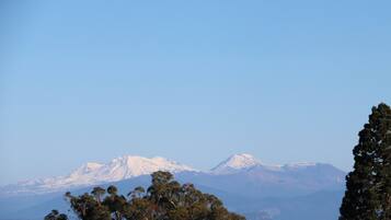A mountain range with snow-capped peaks and a body of water in the foreground.