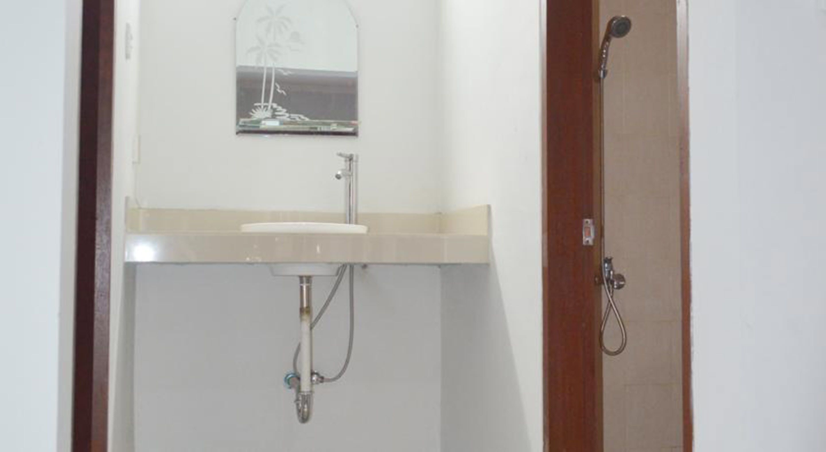 A bathroom with a sink, mirror, and shower.