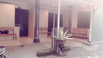 A covered outdoor area with benches and a potted plant.