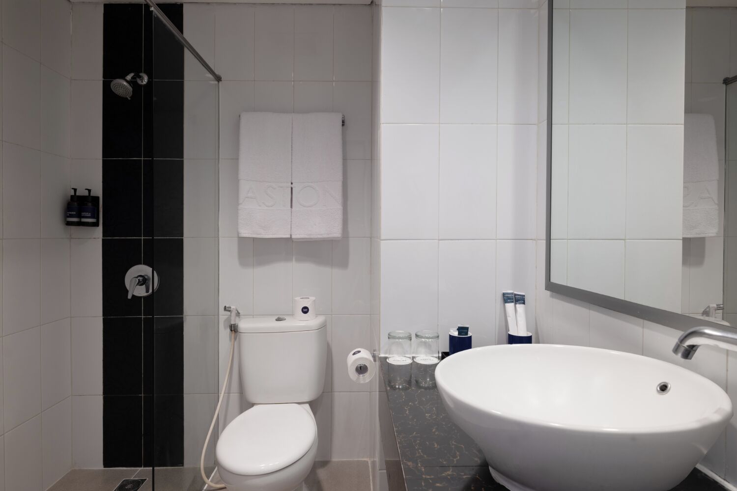 Un baño moderno con inodoro, lavamanos y ducha.