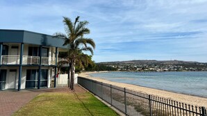 A beachfront hotel with a pool, palm trees, and a view of the ocean and distant hills. - Best Western Port Lincoln (Port Lincoln)