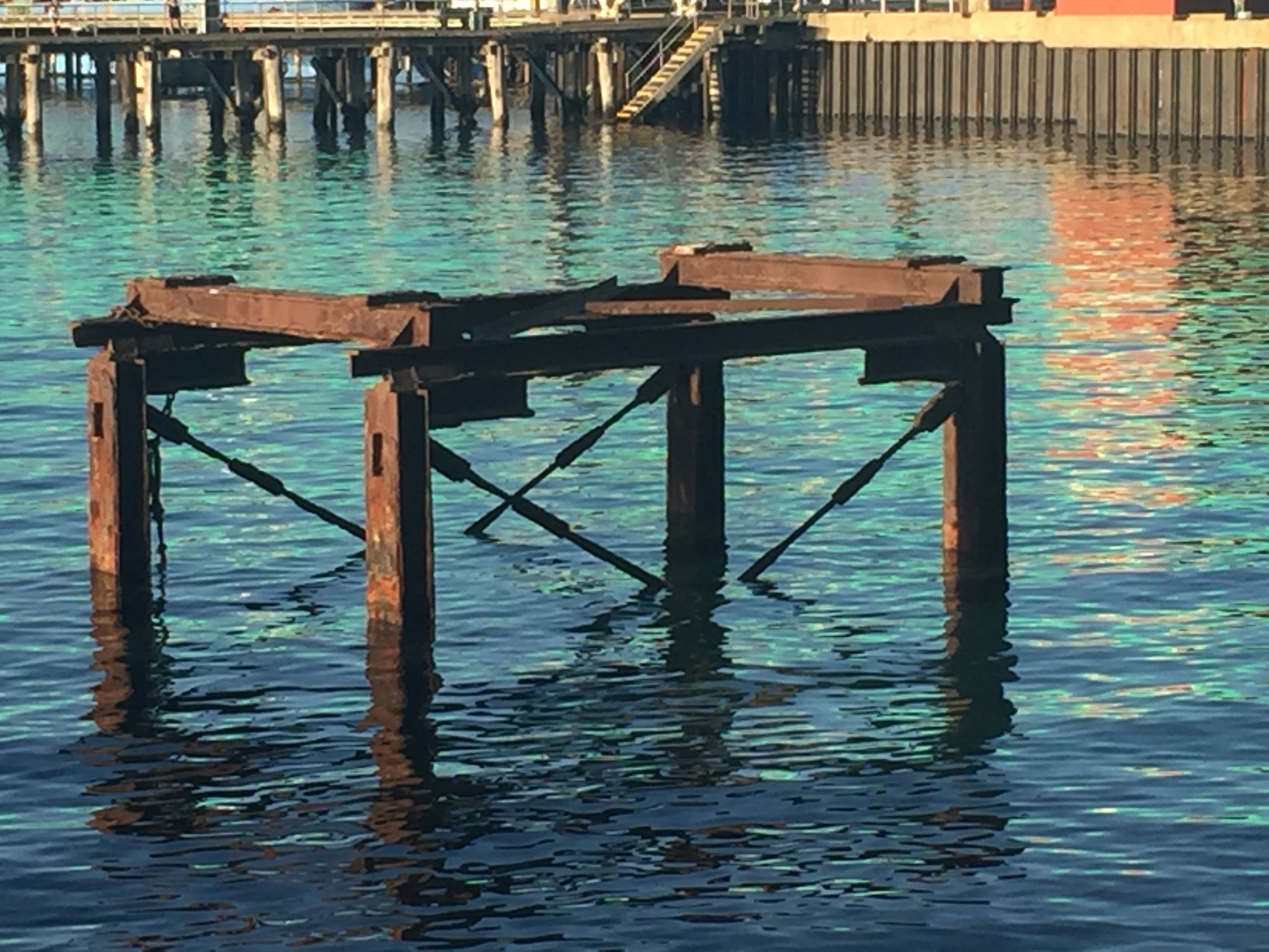 Eine Holzstege, der sich über ein Gewässer erstreckt, das klare Spiegelungen zeigt.